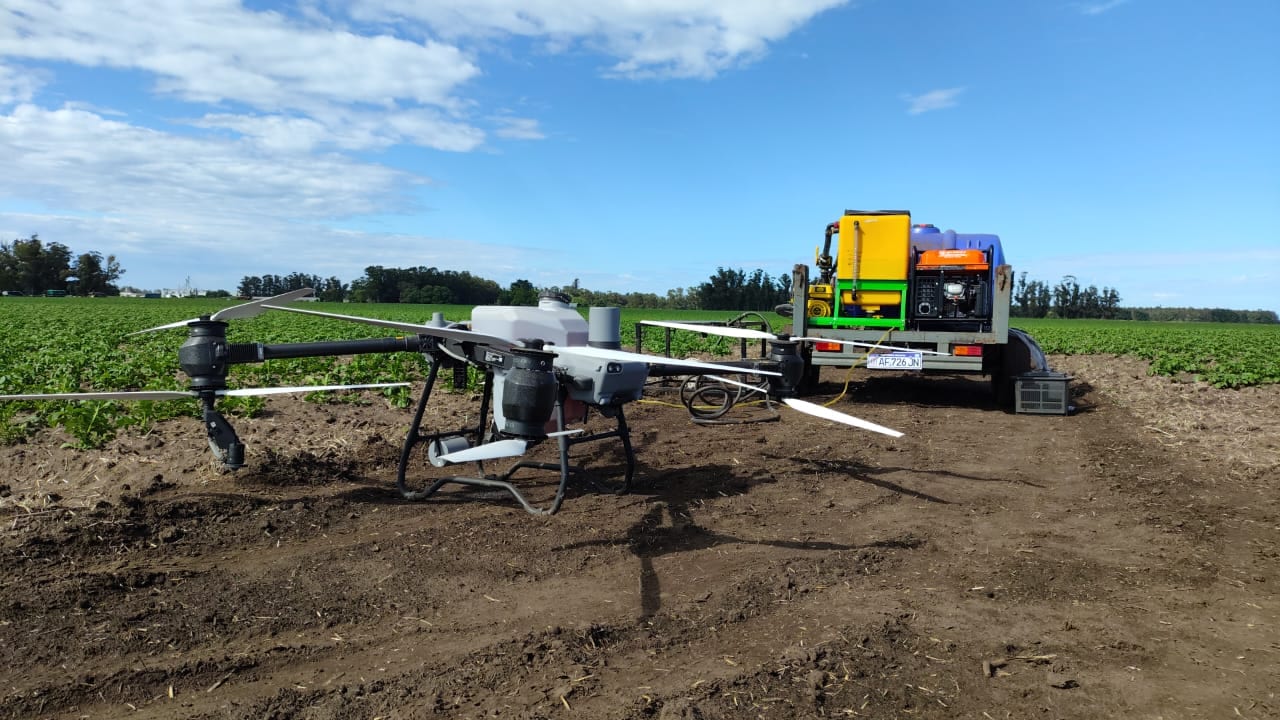 Drone agrícola apoyado en el lote de papa junto al camión de carga